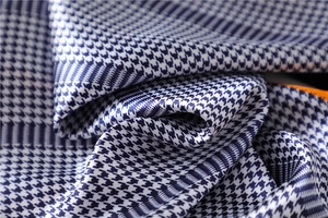 Macro shot of dark blue and white houndstooth silk scarf fabric with a satin luster