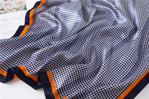 Detail view of satin houndstooth scarf with navy and orange contrast borders