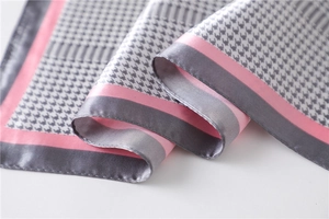 Detail of gray houndstooth silk scarf showing satin texture and pink border accents