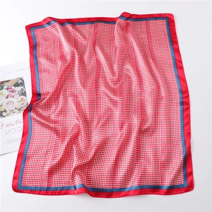 Macro detail of red and white houndstooth pattern square silk scarf with blue border