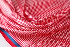 Macro shot of houndstooth silk scarf showing glossy satin texture and colorful edges