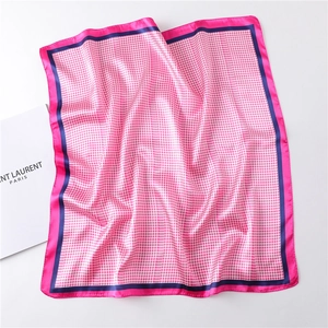 Detail of pink houndstooth square silk scarf showing satin texture and contrast borders