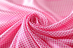 Detailed macro view of pink and white houndstooth pattern silk scarf fabric texture