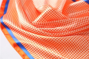 Close-up of houndstooth silk scarf showing luxurious satin texture and vibrant edges