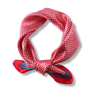 Elegant red and white houndstooth silk scarf with navy trim in a tied knot display