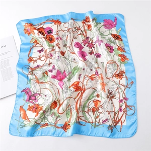 Close-up of square floral silk scarf with butterfly print and light blue borders