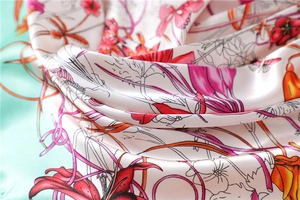 Macro detail of silk scarf featuring floral butterfly print and premium fabric texture