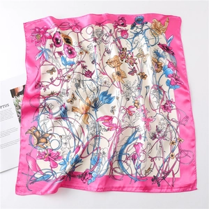 Detail of silk scarf showing vibrant floral and butterfly patterns with clean stitching