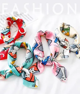 Primo piano di quattro foulard quadrati colorati con stampe di gatti e seta lucida