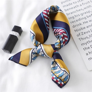 Detail of printed silk scarf with ginger and navy geometric patterns and luxury texture