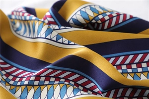 Detailed view of silky square scarf with vintage geometric patterns and vibrant color block