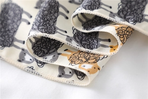 Macro detail of cartoon sheep pattern print on soft cream fabric with neat edge stitching