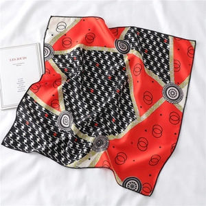Detail of orange and black houndstooth silk square scarf with floral geometric patterns