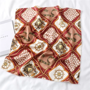 Detailed flat lay of a nautical silk square scarf with rope and crest patterns on linen
