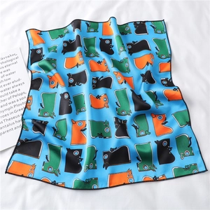Close-up of bright blue silk scarf with cartoon boot prints and fine black stitched edges
