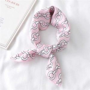 Close-up of pink silk scarf tied in a knot featuring a modern gold chain link pattern