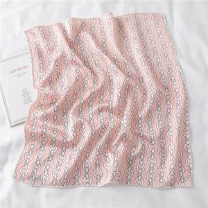 Close-up of pink silk square scarf with chain patterns and fine rolled edge stitching