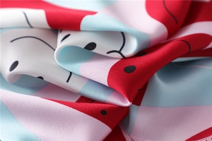 Detailed view of satin square scarf with colorful geometric patterns and black dots
