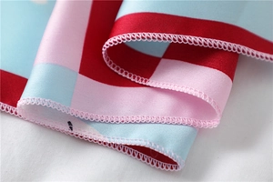 Macro shot of geometric checkered silk scarf showing red and pink overlock stitching