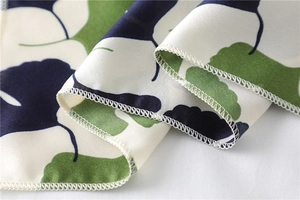 Close-up of botanical print satin scarf showing premium silk texture and neat stitched edges