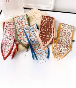 Mise à plat de plusieurs foulards en soie floraux en rouge, vert, bleu et jaune