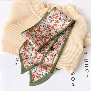 Gros plan détaillé du foulard twilly floral double couche avec ourlet vert et texture fine
