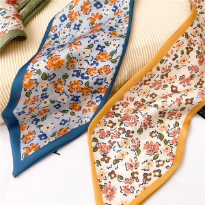 Détail macro de foulards étroits en imitation soie avec imprimés floraux et bords cousus