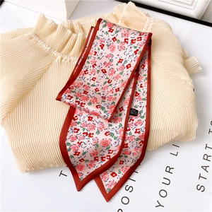 Vue détaillée d'une écharpe à fleurs avec étiquette 100% polyester et bordure contrastée