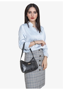 Détail du sac sous le bras en simili cuir noir avec fini brillant vintage et boucle dorée