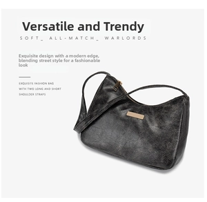 Détail du sac sous le bras en PU noir craquelé avec zip doré et deux bandoulières