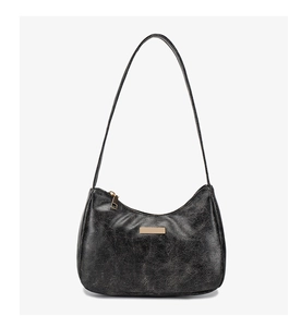 Gros plan détaillé du sac porté épaule noir brillant avec texture cuir craquelé vintage