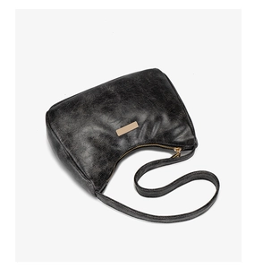 Détail du sac sous le bras en similicuir noir vintage avec fermeture éclair dorée