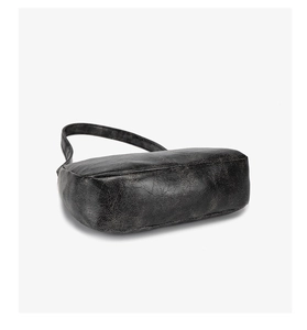 Vue détaillée de la texture craquelée rétro et de la base large du sac à bandoulière noir