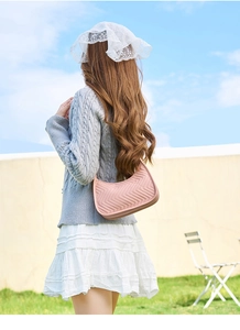Close-up of pink chevron quilted hobo bag styled with a minimalist autumn outfit