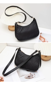 Detail of black quilted faux leather shoulder bag featuring stylish V-shaped stitching