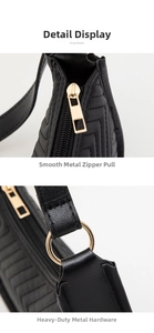 Detail view of black underarm bag featuring V-shaped quilting and gold metal hardware