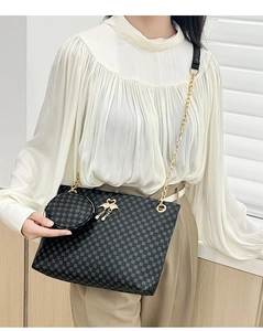 Detail of black twill barrel bag with golden chain strap and a small round coin purse