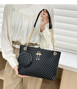 Detail of crossbody barrel bag with gold swan logo and detachable round coin purse