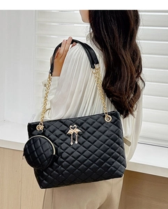 Detail of black quilted barrel bag featuring gold chain strap and flamingo charms