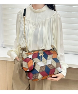 Detail of color-block cylinder bag with gold chain strap and mini round coin purse