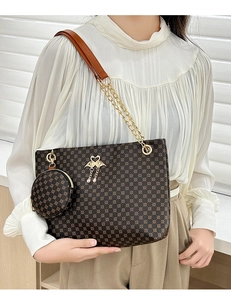Detail of classic patterned cylinder bag with gold swan pendant and chain strap