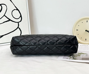 Detail view of the black quilted faux leather crossbody bag's side and bottom texture