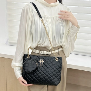 Quilted cylinder shoulder bag in black leather with golden swan charm and mini pouch