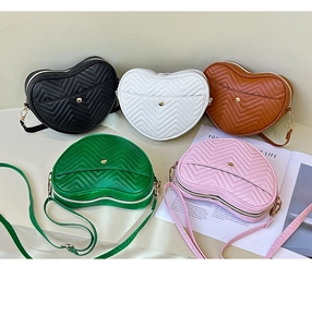 Detailed view of heart-shaped crossbody bags in five colors with V-quilted faux leather