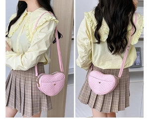 Detail of pink heart-shaped crossbody bag with chevron quilting and adjustable strap