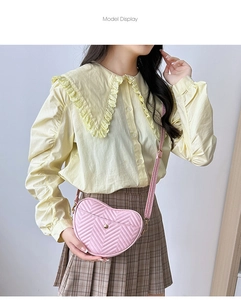 Detail of pink heart-shaped crossbody bag featuring chevron quilting and gold button pocket
