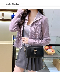 Compact black crossbody bag with V-quilt pattern and elegant swan tassel charm detail