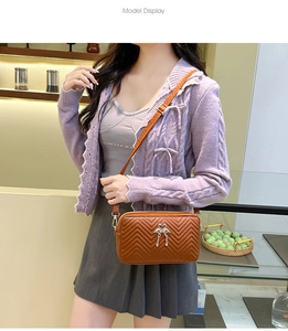 Brown leather crossbody bag with chevron quilting and swan heart metal logo detail