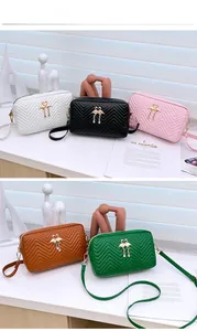 Quilted mini crossbody camera bags in various colors with a gold swan pendant charm