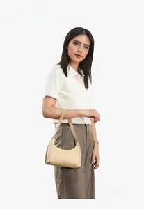 Detailed close-up of beige woven texture and leather strap on a stylish baguette bag